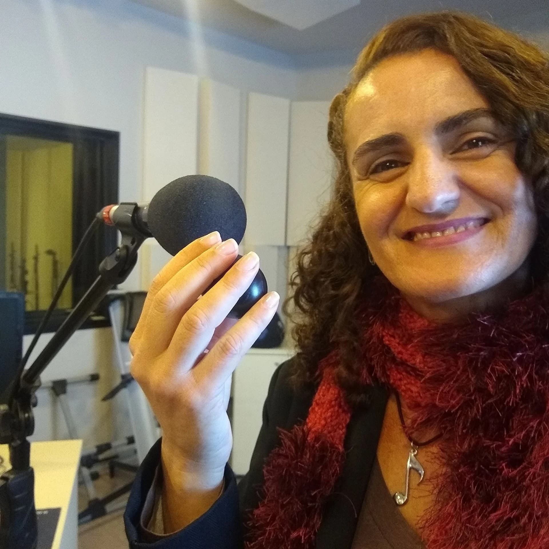 Nellva sorrindo e segurando um microfone